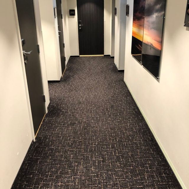 Grått teppegulv i korridor