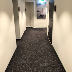 Mørkt teppegulv i gang på hotell