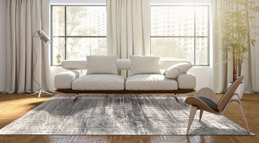 Moderne lys sofa og gulvteppe foran vindu